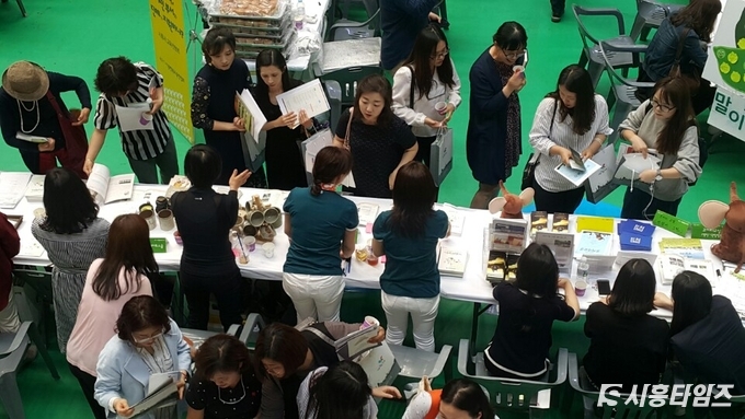 박람회에 참석한 시민들이 시흥시 교육프로그램에 대해 설명을 듣고 있다.