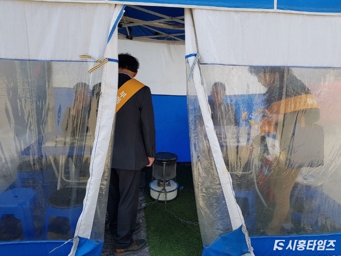 시흥시청 민원지적과(특별사법경찰) 공무원들이 모델하우스 앞 마당 떳다방으로 의심되는 천막에 들어가 지도단속하고 있다.