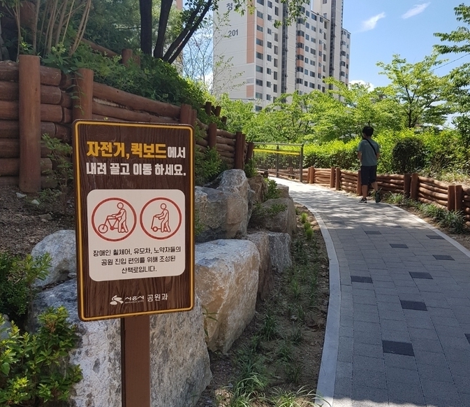 대우3차아파트~금모래초등학교 보행자도로에서 공원 진입 구간. 이곳은 계단으로만 설치되어 있어 장애인은 물론 고령자, 유모차 이용객들의 접근이 어려웠지만 데크 경사로 설치를 통해 접근성을 개선했다.