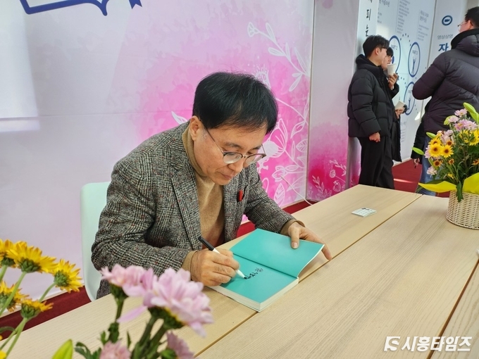 정필재 위원장이 책을 구입한 시민들에게 직접 사인을 해주는 모습