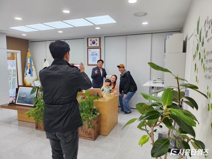 3일 임병택 시흥시장이 시장실을 찾은 어린이를 시장석에 앉히며 가족들과 기념 촬영을 하고 있다.