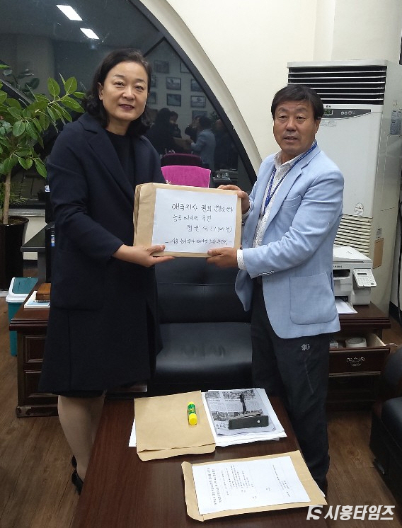 지난 28일 시흥능곡역사 테마역 추진위가 함진규 국회의원의 부인인 성경진 여사에게 청원서를 전달하고 있다. 사진 좌측이 성경진 여사, 우측이 테마역 추진위원장 서예식(자료제공: 시흥능곡역사 테마역 추진위원회)